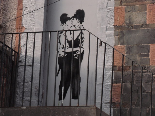 Bansky graffiti, of two Bobbies (British police officers) in a passionate embrace