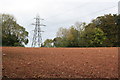 SX8463 : Powerline over a Ploughed Field by Tony Atkin