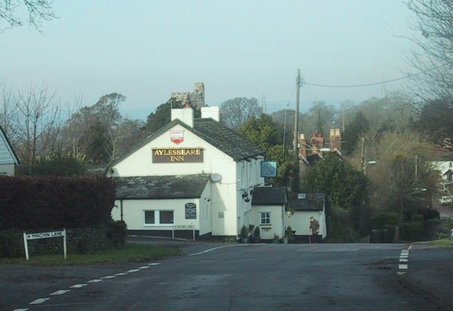 The road drops past the Aylesbeare Inn © Sarah Charlesworth cc-by-sa/2. ...