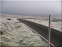 NY7131 : Snow poles on access road to Great Dun Fell Radar Station by Phil Catterall