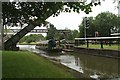 Plank Lane lift bridge, lifted, with a narrow boat passing beneath