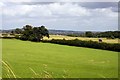 Looking across a field towards the bridleway and a tractor