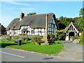 Thatched cottage, preaching cross and lych gate