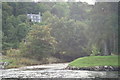 Tree clad house overlooking the river Fiddich