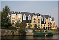 A working narrowboat passes new flats in Maidstone