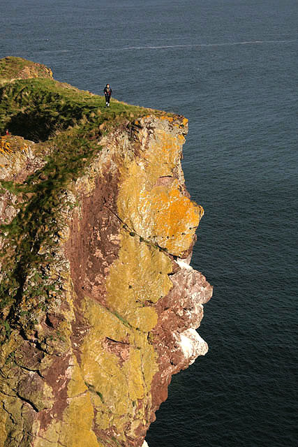 A walker on cliffs at White Heugh