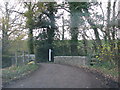 Public footpath leaves the road beyond the bridge