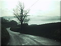 Road drops towards Sandford and a misty valley