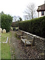 Seats on the church path at The Assumption, East Wittering