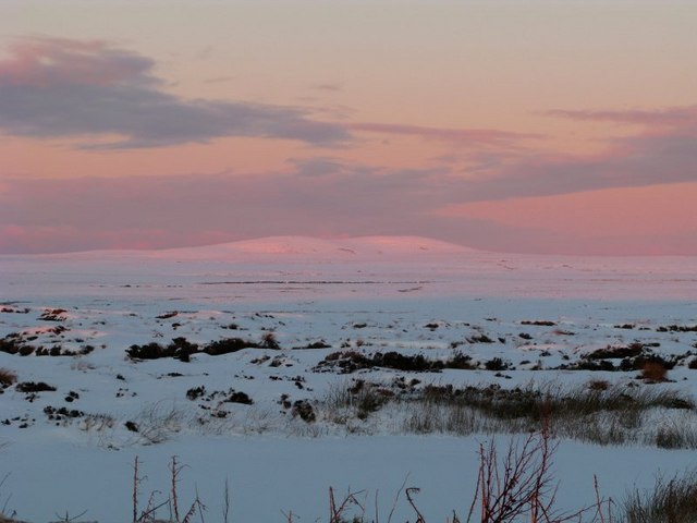 A snowy Muirneag reflecting the setting sun