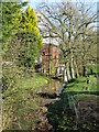 Evegate Mill and mill stream through the trees