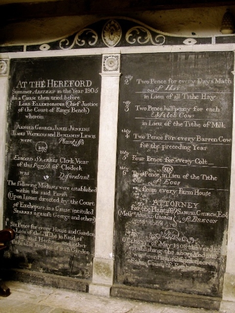 A carved record of the judgement in a tithe dispute, in a darkened corner of Clodock Church