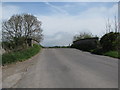 Road rises to bridge over disused railway