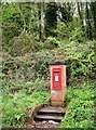 A postbox in isolation, with its own steps