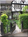 TQ1981 : Wooden gate, privet hedge and half-timbered house by David Hawgood