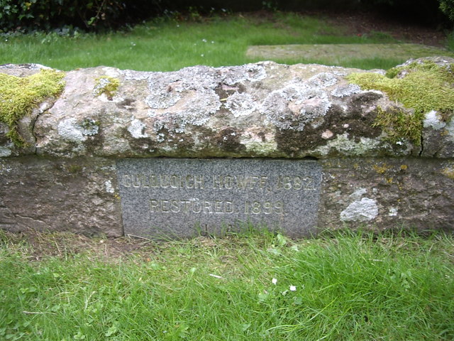 A plaque on a low wall around an old grave slab, Migvie