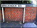 Benchmark and street sign at junction of Brecknock Road and Wells Road