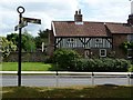 Old signpost and even older house