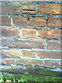 Benchmark on wall at SW side of High Street