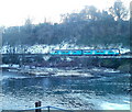 Railway train viewed across the River Taff, Radyr, Cardiff