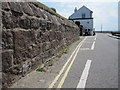 Old stone wall and a bench mark in The Parade