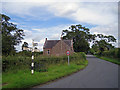 Road sign, seat and church, Wetheral