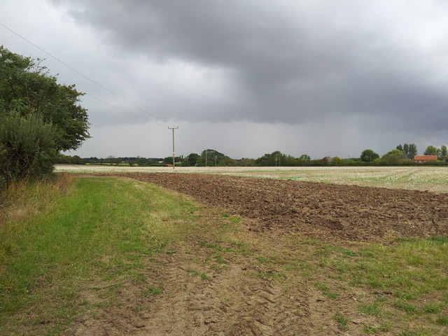 Newly ploughed fields under storm clouds