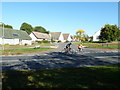 Cyclists passing the junction of  Send Barns Lane and Amberley Close