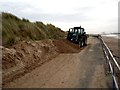 Removing wind blown sand.