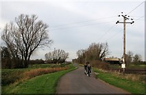 TL5263 : Cyclists on Fen Road by John Sutton