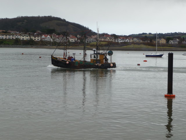 Boat heads down the Afon Conwy towards the sea