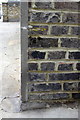 Benchmark on garage block, Queensdale Road