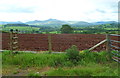 A ploughed field and a distant view of the Brecon Beacons