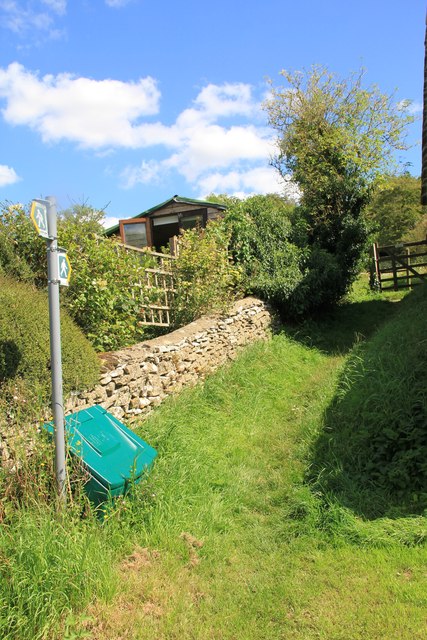 Path climbs away from lane in Chedworth
