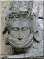 NY7756 : Holy Trinity Church, Whitfield - stone head on porch (2) by Mike Quinn