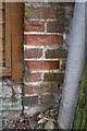 Weathered benchmark on Old Stable Cottage, Clappentail Lane