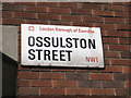 Street nameplate mounted on dark red brick