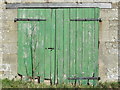 Green doors in barn near Newbrough Hall