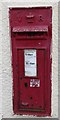 Old post box in a young building