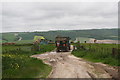 TQ0312 : Tractor and trailer arriving at Downs Farm by Chris