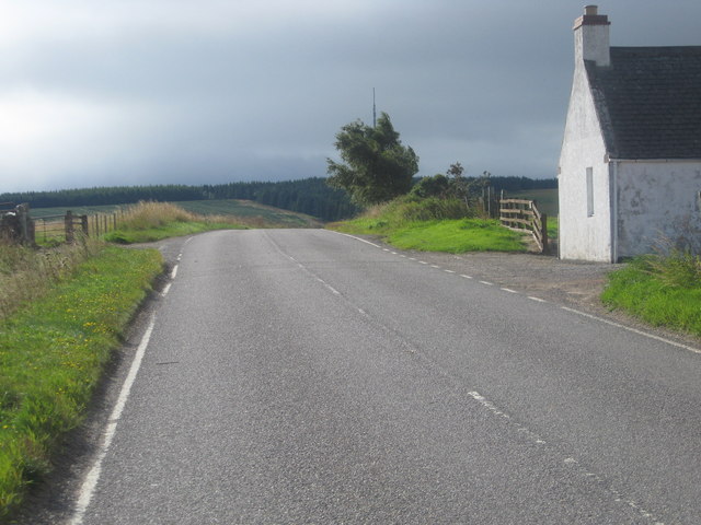 The A832 heading south past a roadside cottage