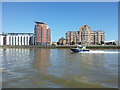 Police river boat passing riverside apartments on the Isle of Dogs