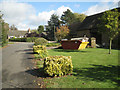 Roadside shrubs and skip, Elmers Farm, Priors Hardwick