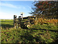 Stile and signpost at a junction of paths in fields