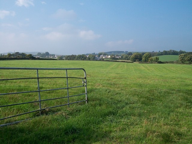 View across a harvested hay field towards the village of Bryansford