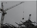 Construction workers being hoisted by a crane