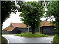 TL5107 : Barns at a junction of country lanes by Bikeboy