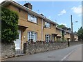 Modern houses behind an older stone wall