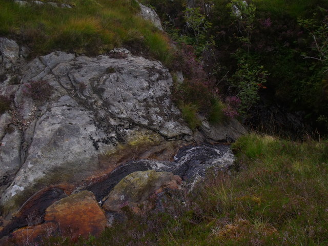 Solid rock water chute above waterfall on Allt Fiachlach north of Ben Lomond