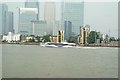 View of a Thames Clipper speeding past Canary Wharf